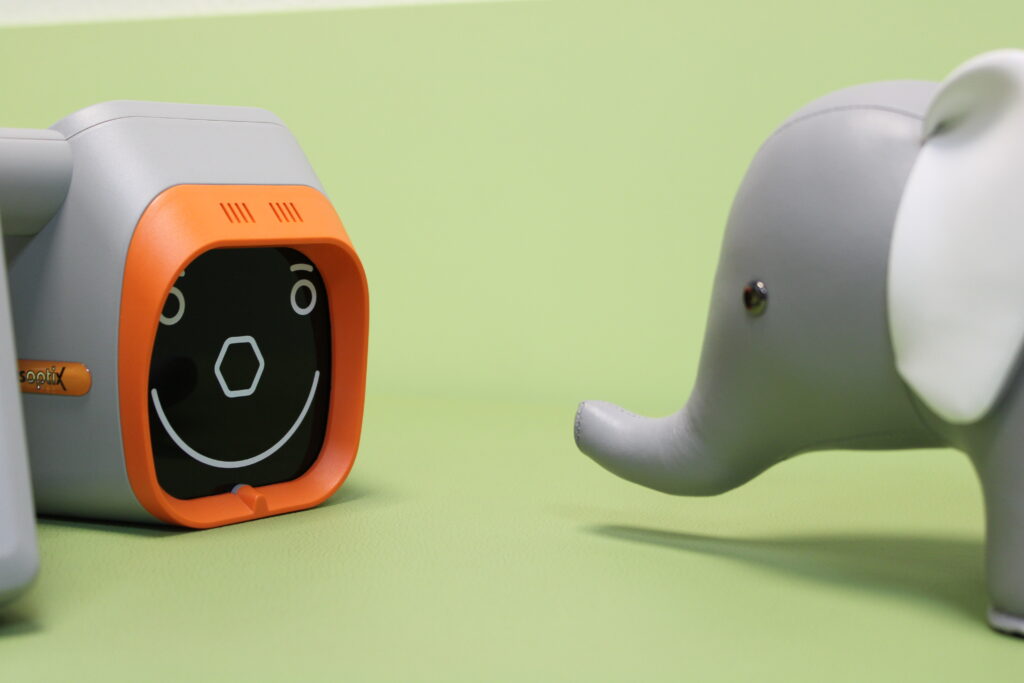 Nahaufnahme vom Praxismaskottchen vor einem medizinischen Gerät.